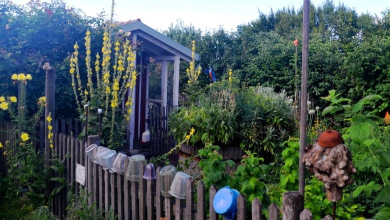 hochbeet_klein_farbe_c_familie-mahr, © Familie Mahr Ein kleiner Garten mit Hochbeet, umgeben von einem Holzzaun und blühenden Pflanzen.