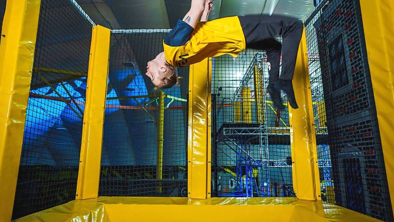 Jumpin Warrior, © © Echte Freude Person macht einen Rückwärtssalto auf einem Trampolin in einer Halle.