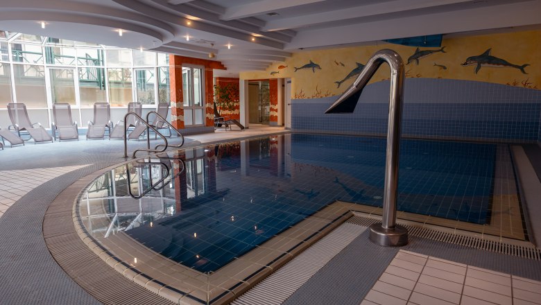 Hotel Schneeberghof, © Niederösterreich Werbung / Maximilian Pawlikowsky Innenansicht eines Hotelpools mit Liegestühlen und Wandmalerei von Delfinen.