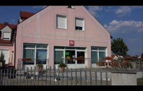 Bäckerei-Café Hiessberger, © Donau Niederösterreich Außenansicht eines rosa Gebäudes mit der Aufschrift 'Bäckerei-Café Hiessberger'. Vor dem Gebäude stehen Tische und Stühle.