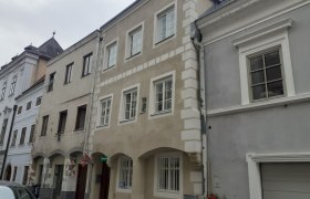 Außenansicht, © Maria Puchmayr Reihenhäuser in einer europäischen Stadt mit gepflasterter Straße.