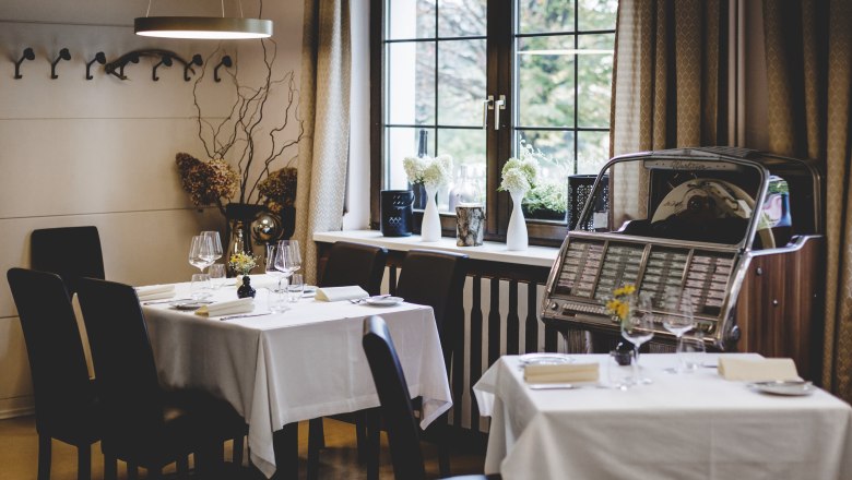 Ungezwungene Wohlfühlatmosphäre, © Niederösterreich Werbung/David Schreiber Gemütliches Restaurant mit gedeckten Tischen und Jukebox am Fenster.