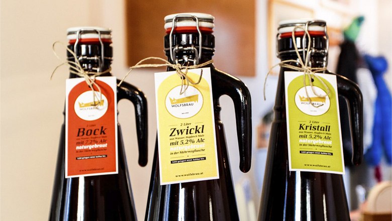 Wolfsbräu – das bucklige Weltbier, © Familie Wagner, Marco Rossi Drei Bierflaschen mit Etiketten von Wolfsbräu: Bock, Zwickl und Kristall.
