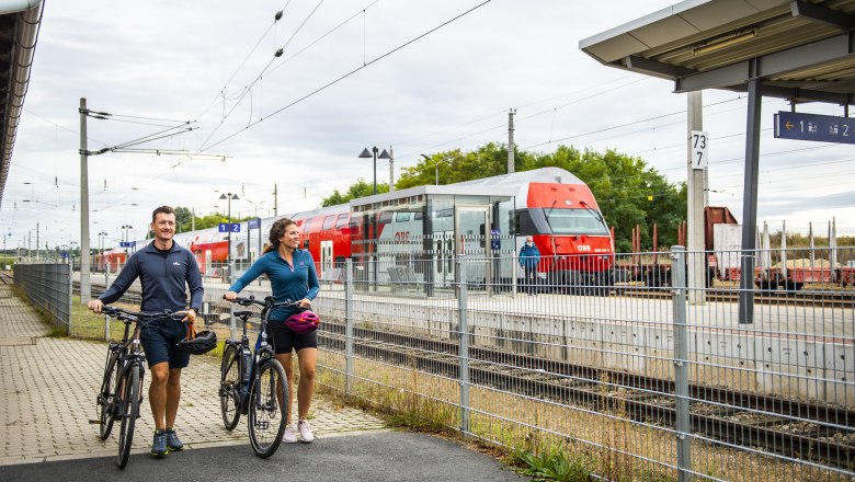 Bahnhof, © Weinviertel Tourismus GmbH / POV / Robert Herbst Zwei Personen mit Fahrrädern am Bahnhof Retz, im Hintergrund ein ÖBB-Zug.