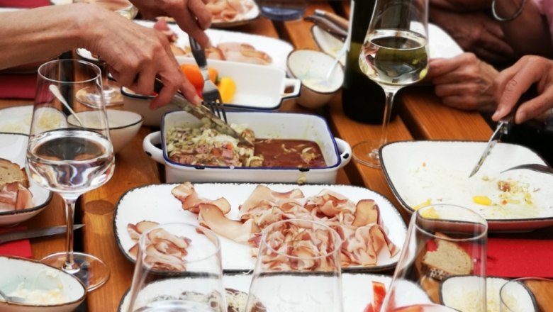 pfefferschiff_essen1, © Iris und Jürgen Vigne Menschen essen gemeinsam an einem Tisch mit verschiedenen Speisen und Getränken.