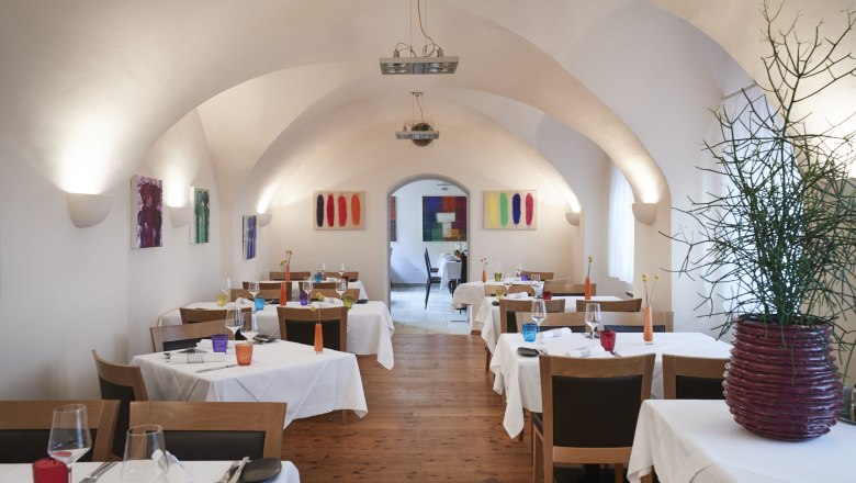 Mittelalterliches Gewölbe, zeitloses Ambiente, © Niederösterreich Werbung/Andreas Hofer Ein elegantes Restaurant mit gewölbter Decke, weißen Tischdecken und bunter Dekoration.