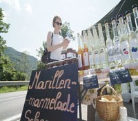 Marillenverkauf, © Steve Haider Ein Verkaufsstand mit Marillenmarmelade und Schnaps an einer Straße.