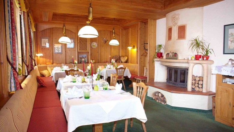 Kaminstüberl, © Familie Pichler Gemütlicher Raum mit Holzwänden, gedeckten Tischen und Kamin.