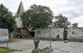 Stadtmauer in Horn, © Roman Zöchlinger Stadtmauer und Museum in Horn mit Statue und Infotafel im Vordergrund.