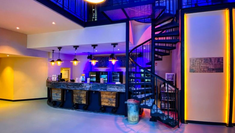 Bar - Papierfabrik Varieté, © Manfred Sebek Innenansicht einer Bar mit Wendeltreppe und blauer Beleuchtung.