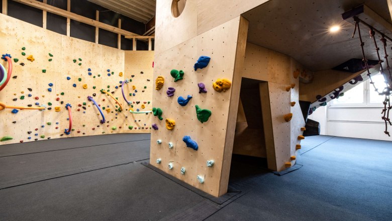 BigWall Bouldering Littlewall, © BigWall Bouldering Innenansicht einer Kletterhalle mit bunten Klettergriffen an Holzwänden.