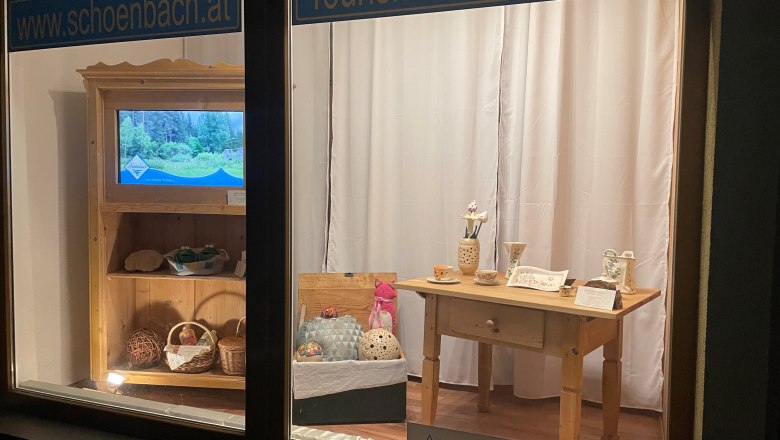 Infostelle Schönbach, © Marktgemeinde Schönbach Schaufenster mit Tourismusinformationen und handgefertigten Produkten.