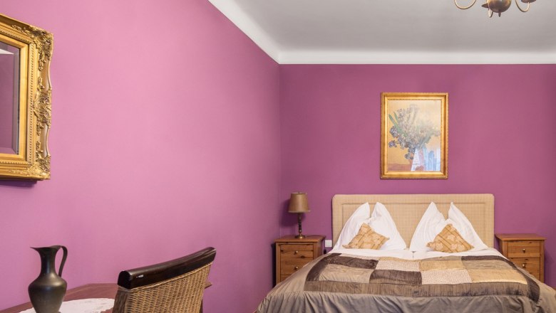 TDR-Zimmer rosé, © Nibelungenhof an der Donau Ein gemütliches Gästezimmer mit Doppelbett und Kronleuchter