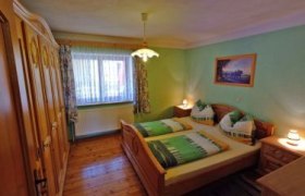 Zimmer Familie Pieringer, © Fam. Pieringer Gemütliches Schlafzimmer mit Doppelbett, Holzmöbeln und grünem Dekor.