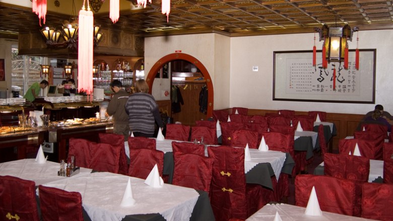 Sitzgruppe, © Chinarestaurant Evergreen Innenansicht eines asiatischen Restaurants mit roten Stühlen und gedeckten Tischen.