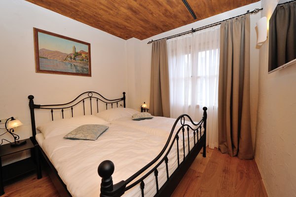 Heritage Dürnstein, © Gregor Semrad Schlafzimmer mit Metallbett, Holzboden und Gemälde an der Wand.