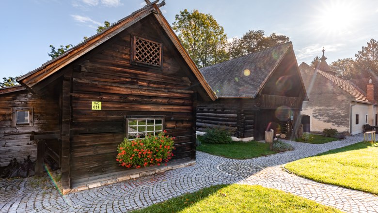 Museumsdorf Krumbach, © Wiener Alpen, Christian Kremsl Traditionelle Holzhäuser im Museumsdorf Krumbach bei Sonnenschein.