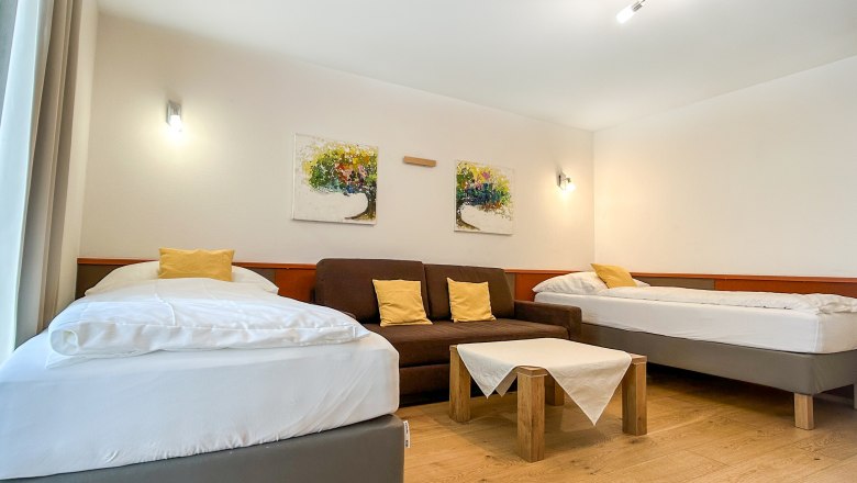Haus Morgensonne Schlafzimmer V, © Fam. Pauker Schlafzimmer mit zwei Betten, Sofa und Tisch.