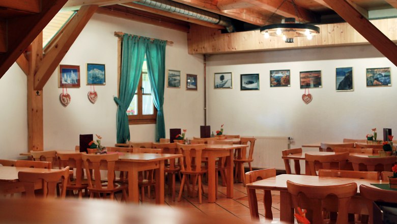 Mostheuriger Moderbacher, © weinfranz.at Innenansicht eines rustikalen Gastraums mit Holzmöbeln und Bildern an der Wand.