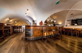 RHK Schank, © Lorenz Wachau Innenansicht eines rustikalen Gastraums mit Holzboden und gewölbter Decke.