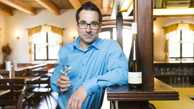 Franz Tanzer im Heurigen, © Franz Tanzer Mann im blauen Hemd mit Weinglas in einem rustikalen Restaurant.