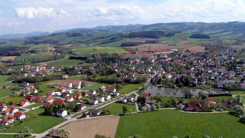 Seitenstetten, © zVg Gemeinde Seitenstetten Luftaufnahme von Seitenstetten mit Feldern, Häusern und Hügeln im Hintergrund.