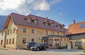 Täglich frisches Gebäck aus der hauseigenen Bäckerei, © Wiener Alpen Ein traditionelles Gasthaus mit Bäckerei und geparkten Autos davor.