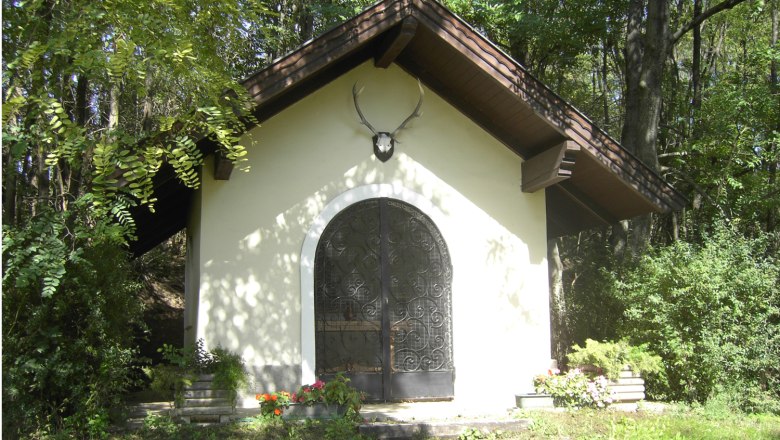 Hubertuskapelle in Leobendorf, © Gemeinde Leobendorf Eine kleine Kapelle im Wald mit einem Hirschgeweih über der Tür.