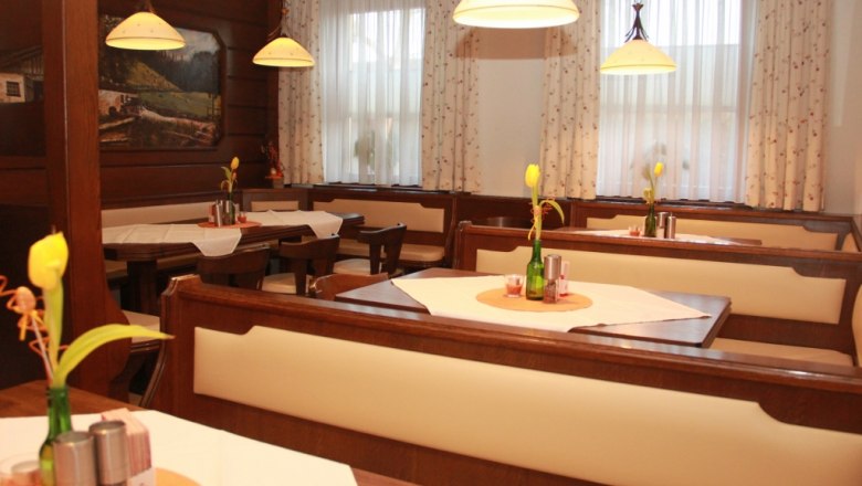 Stüberl, © Mühlendorfer Michael Gemütliches Stüberl mit Holzmöbeln, Tischdekoration und Lampen.