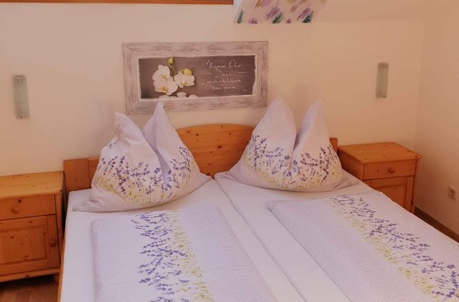 Weingut Krell, © Weingut Krell Gemütliches Schlafzimmer mit Dachfenstern und Blumenbettwäsche.