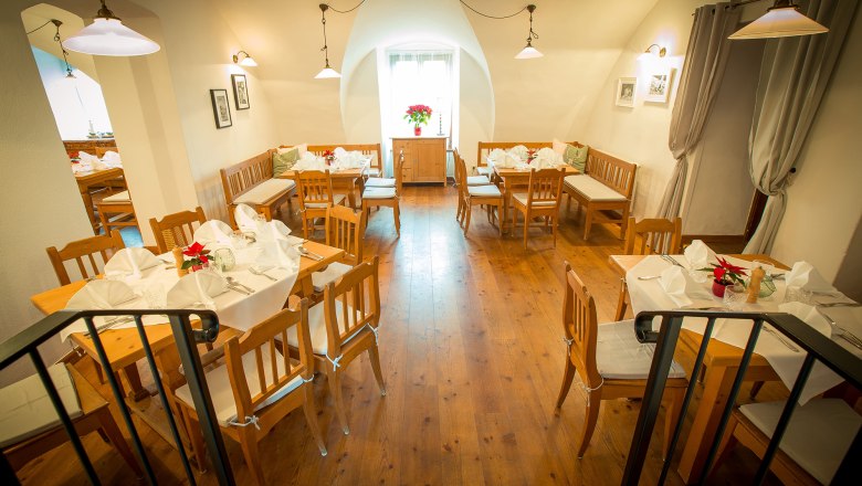 Stüberl, © Schlossschenke Gemütliches Restaurant mit Holzmöbeln und weiß gedeckten Tischen.