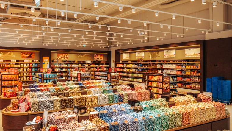 Riesen Shopangebt, © Philipp Lipiarski Ein großer Süßwarenladen mit bunten Pralinen und Schokoladenregalen.