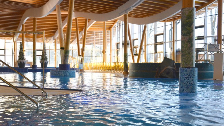 Hotel Sole Felsen Welt, © Sole Felsen Welt - Peter Baier Innenansicht eines modernen Schwimmbads mit Holzsäulen und großen Fenstern.