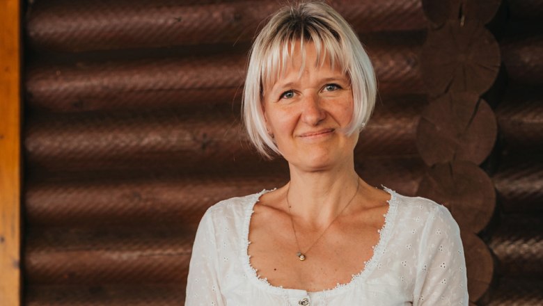 Wirtin Andrea Bamberger, © Niederösterreich Werbung/Daniela Führer Frau mit blonden Haaren vor Holzwand
