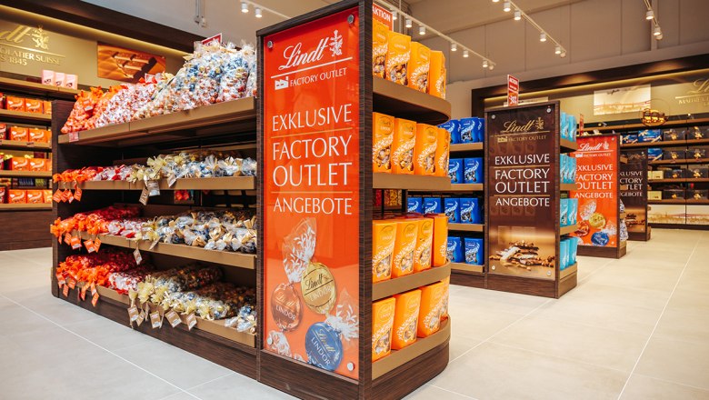 Outlet Angebote, © Philipp Lipiarski Regale mit Lindt Schokolade in einem Outlet.