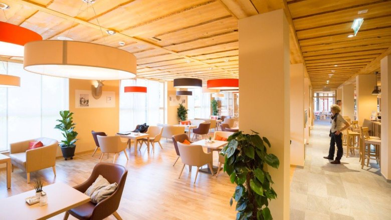 Lobby JUFA Hotel Annaberg***s, © Fred Lindmoser Lobby des JUFA Hotels Annaberg mit modernen Möbeln und großen Lampen.