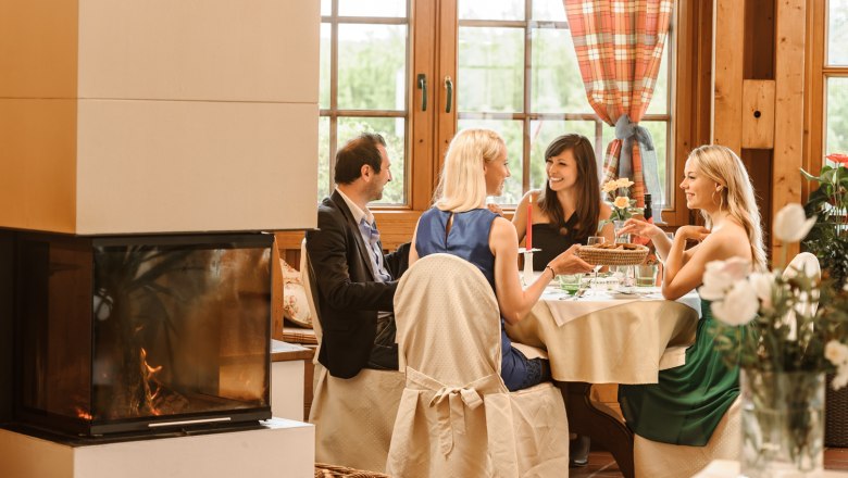 Wintergarten Landhotel Wachau, © Familie Pichler Vier Personen sitzen an einem Tisch in einem gemütlichen Wintergarten mit Kamin.