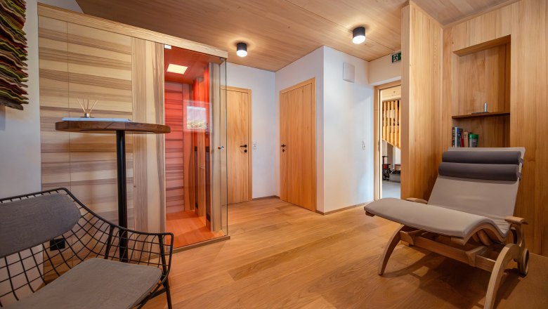 Weinviertler Kellerstöckl Weingut Hindler, © Niederösterreich Werbung / Maximilian Pawlikowsky Innenansicht eines modernen Raumes mit Holzverkleidung, Liegestuhl und Infrarotkabine.