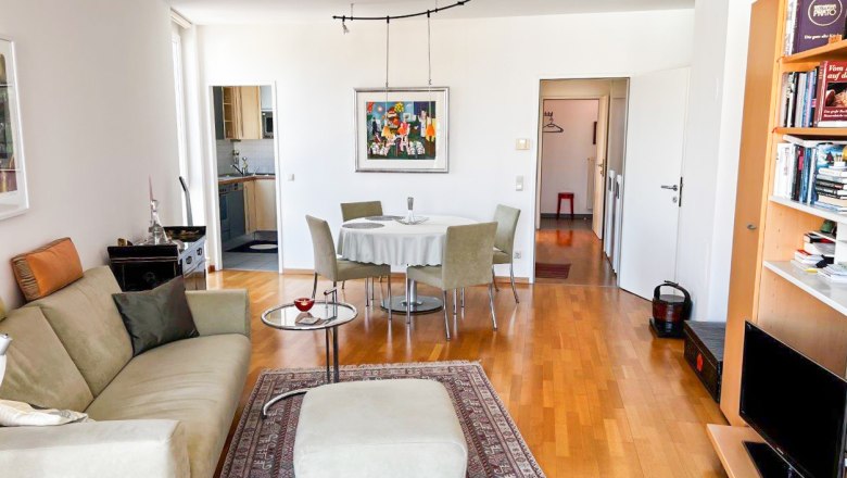 Apartment am Stadtpark, © Apartment am Stadtpark Wohnzimmer mit Sofa, Teppich, Esstisch und Bücherregal.