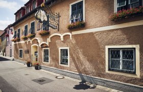 Wachauer Hausmannskost auf Haubenniveau, © Niederösterreich Werbung/Andreas Hofer Traditionelles Gasthaus mit Blumenkästen und dekorativem Schild.