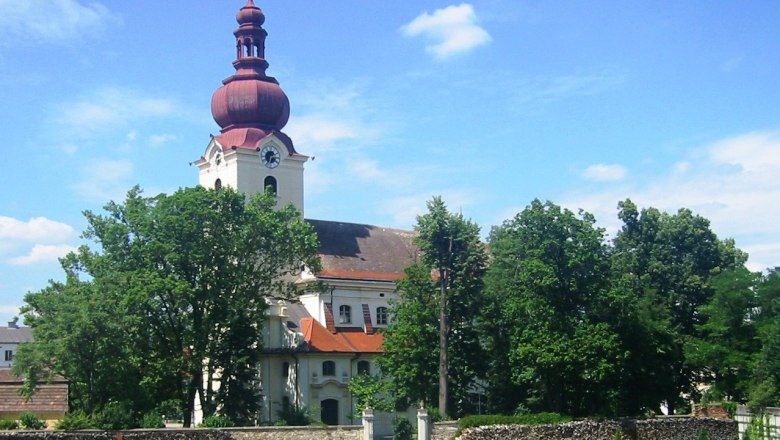 Jakob Prandtauer Kirche, © Marktgemeinde Ravelsbach Barockkirche mit rotem Turm und Garten im Vordergrund.