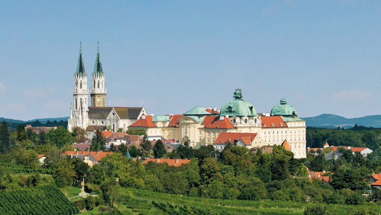 Stift Klosterneuburg, © Michael Zechany Panoramablick auf das Stift Klosterneuburg mit grünen Weinbergen im Vordergrund.