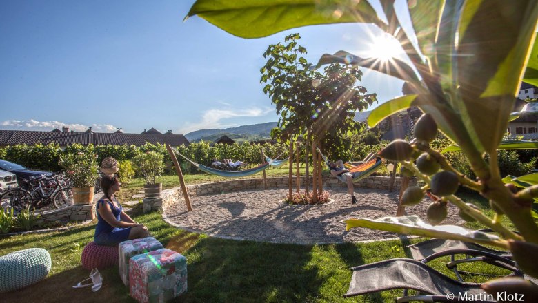 Der mediterane Garten, © Martin Klotz Mediterraner Garten mit Hängematten und Personen, die entspannen.