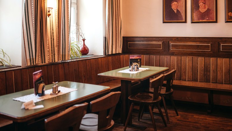 Traditionelle Stube am Dreifaltigkeitsplatz in Zwettl, © Niederösterreich Werbung/Daniela Führer Traditionelle Stube mit Holzmöbeln und Gemälden an der Wand.