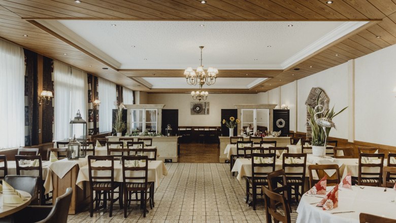 Über 100 jähriges Bestehen des Wirtshauses, © Niederösterreich Werbung/Sophie Menegaldo Innenansicht eines traditionellen Wirtshauses mit gedeckten Tischen und Holzdecke.