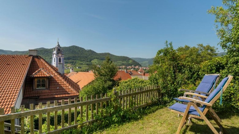 Pension Altes Rathaus in Dürnstein, © Familie Fürtler Blick auf Dürnstein mit Kirche und Liegestühlen im Vordergrund.