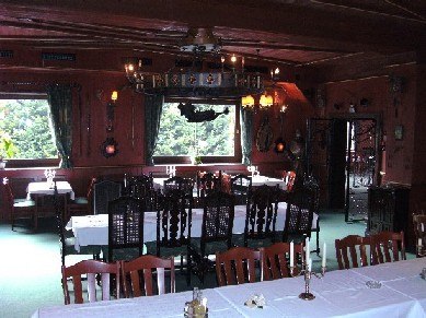 Rittersaal, © Burgherrenrestaurant Ein rustikaler Speisesaal mit Holzmöbeln und Kerzenleuchtern.