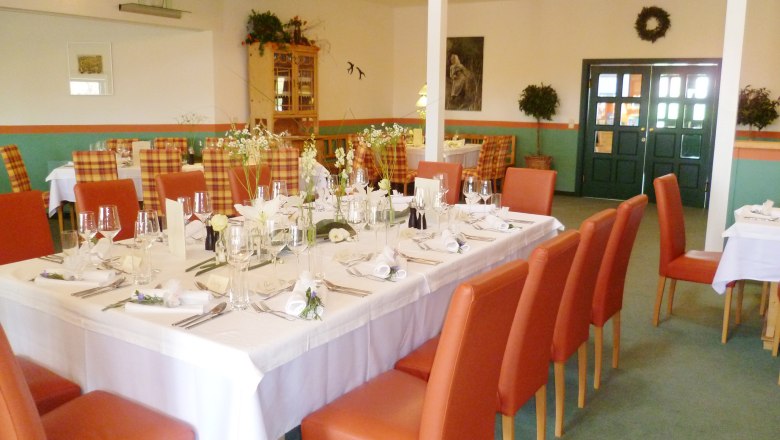 Restaurant Hettegger, © MG Rfd Elegantes Restaurant mit gedecktem Tisch und roten Stühlen.