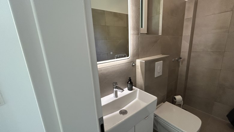 Feigenterrasse am Semmering, © Stupacher Modernes Badezimmer mit Waschbecken, Spiegel und Toilette.