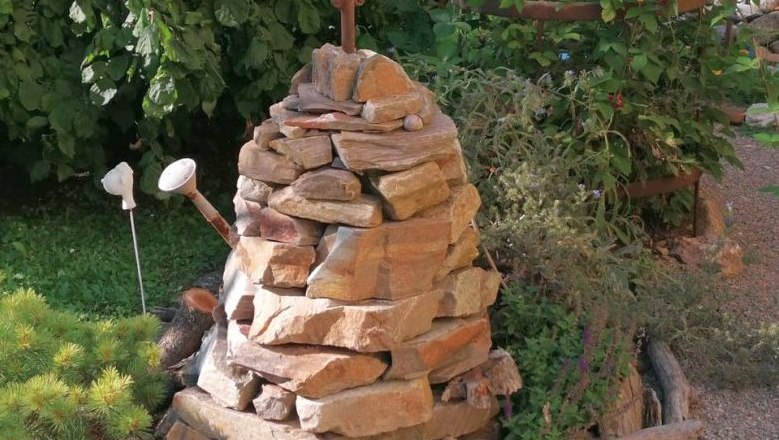 Steinpyramide, © Tina Perina Steinpyramide im Garten mit Dekorationen aus Metall und Holz.